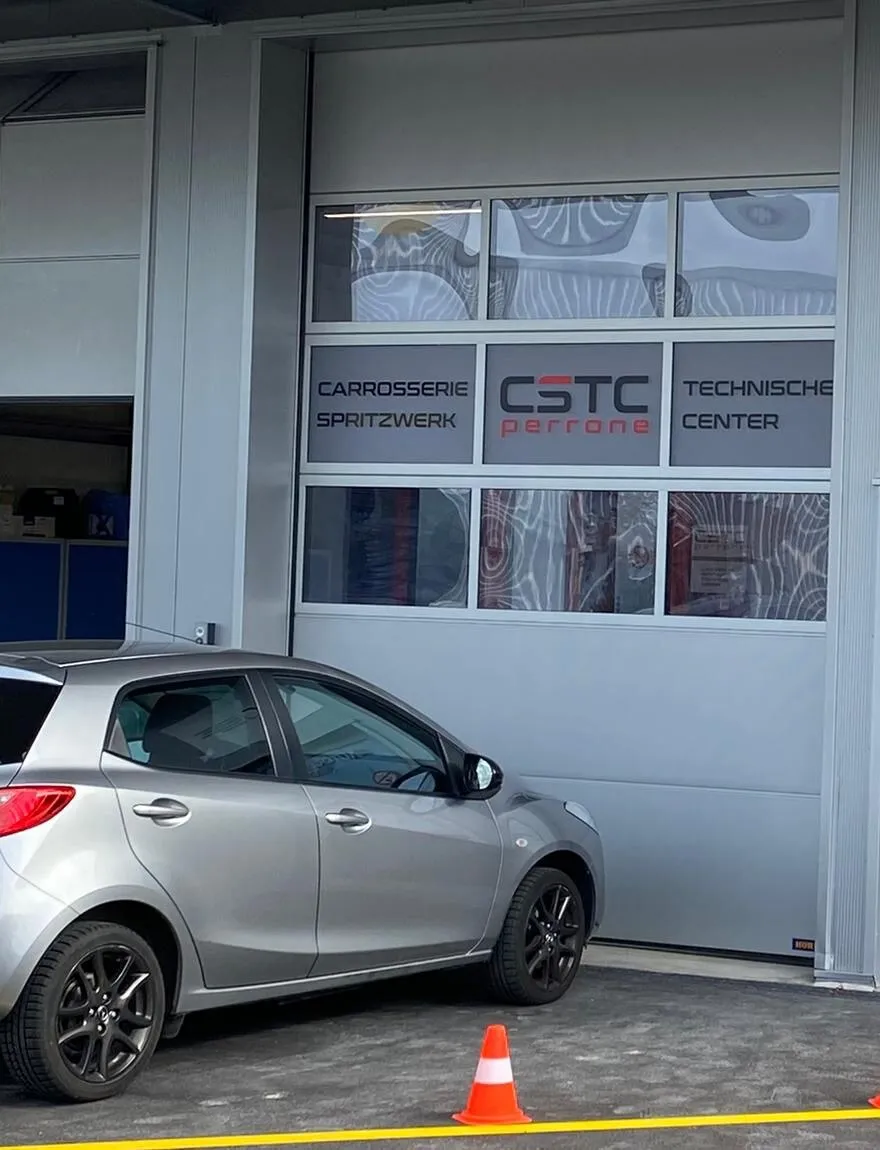 Werkstatttor von CSTC perrone mit Logo und Beschriftung Carrosserie, Spritzwerk, Technisches Center